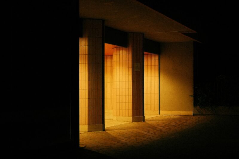 Verlichte gang met tegelmuren in avondlicht.